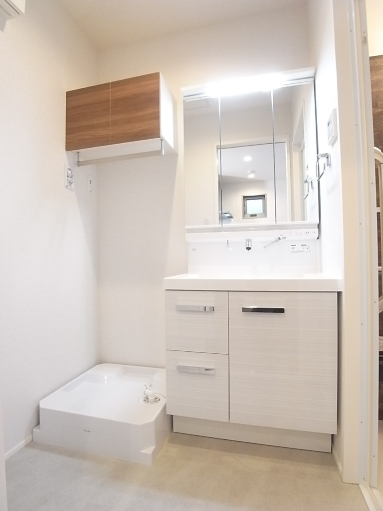 洗面脱衣所。洗濯機置き場の上には便利にお使いいただける棚とバーが付いています！