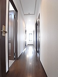 階段からリビングへ向かう廊下。左手に洋室が二間、右手に洗面所等がございます。