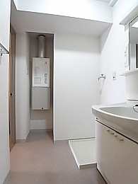 洗面脱衣所。浴室内から撮影。手前は洗面台でその奥が洗濯機置場。