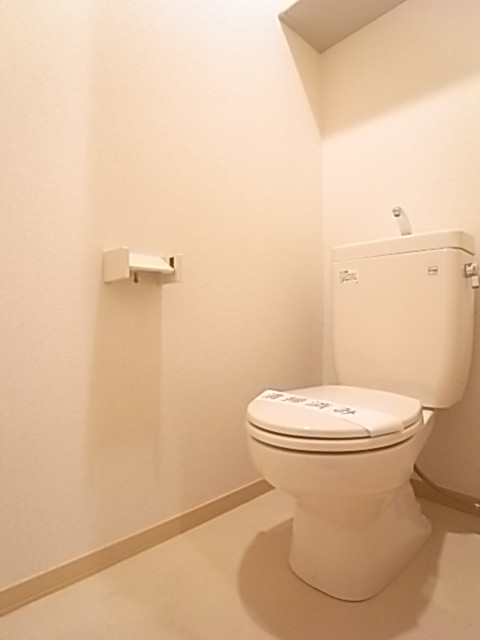 明るく清潔感のあるトイレ。上部棚にペーパー類のストックを。