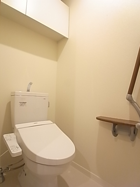 手すり付きのトイレは洗浄機能付き便座。