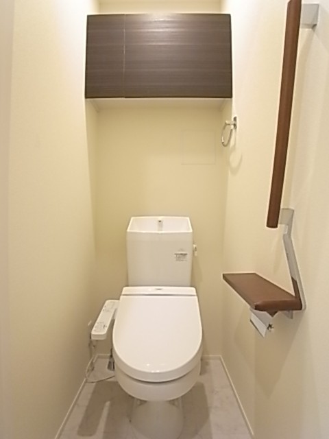 温水洗浄便座付きのトイレ。上部棚にはペーパー類のストックを。