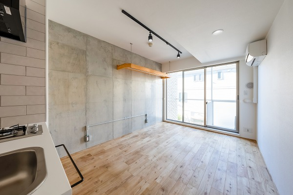 無垢材の床のぬくもりとコンクリート壁のシックさがマッチする部屋