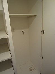洗濯機置き場です。上に棚があるから洗剤や柔軟剤とかもしまえます。